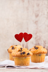 Homemade chocolate muffins with heart, vintage background.