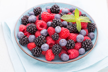 Fresh raspberries in a plate on a  vintage background.