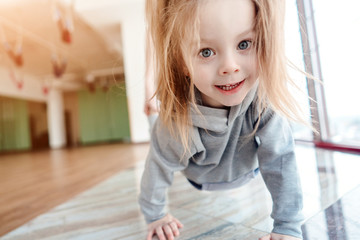 Fototapeta premium Little girl crawls on her hands