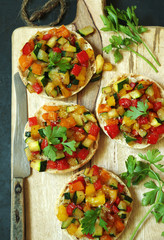 kleine Brötchenpizzen mit buntem Zucchini-Paprika Gemüse und Parmesan