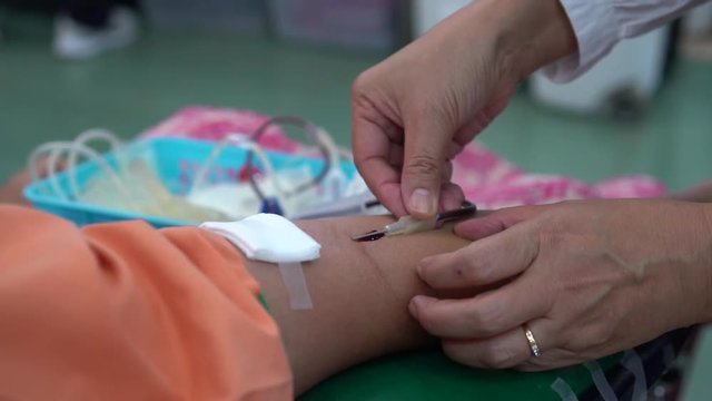 Health and Medical concept. Closeup Hands nurse are using needle to pierce vein bleeding Preparation for blood test. Blood donation occurs when person voluntarily has blood drawn used for transfusions