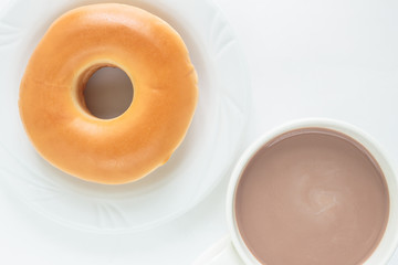 donut on white plate and cup cocoa drink top view on white background.