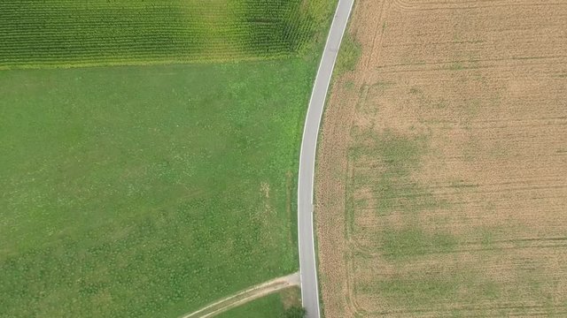 Flying Over a Road Separating a Field in France Near the Isoard Pass