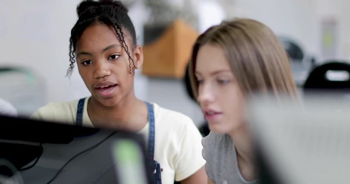 Closeup teenage girls using a computer in class