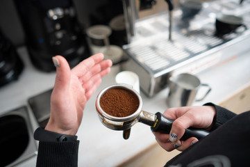 Barista holding portafilter with ground coffee