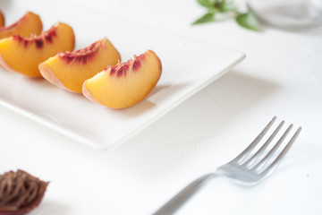 Slices of peach served on a white plate