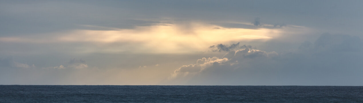 Abstract seascape panoramic background - Orange color in the sky, sunset late afternoon. Calm seas/ocean in the bottom of the frame. Minimalistic simple background image, blue and yellow colors.