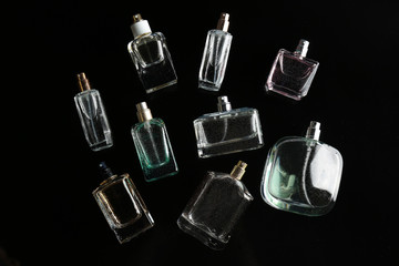 Perfume bottles on black background, flat lay