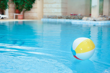 Fototapeta na wymiar Colorful inflatable ball floating on water in swimming pool