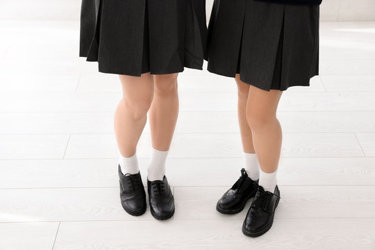 Girls in stylish school uniform indoors, focus on legs