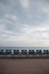 Fototapeta na wymiar Chairs in a row looking out to the beach and sea