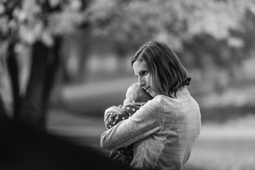 Black and white image of a happy mother hugging her baby girl