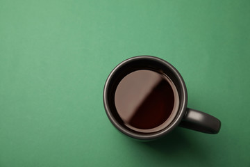 Cup of black tea on color background, top view