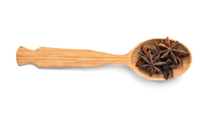 Wooden spoon with anise stars on white background. Different spices