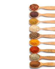 Composition with different aromatic spices in wooden spoons on white background © New Africa