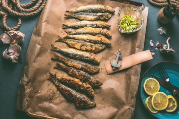 Grilled sardines on baking tray with ingredients: lemon, garlic and herbs for tasty seafood eating....