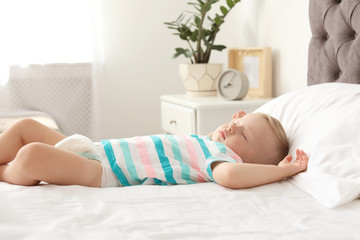 Little child sleeping on bed at home