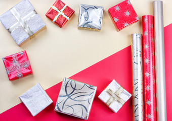 Golden gift boxes and red wrapping paper on bright background