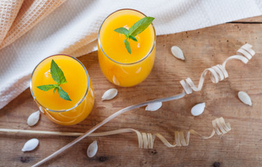 Healthy pumpkin fruit smoothie with seeds and mint leaves . Top view flat lay group objects