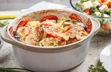 Traditional tasty rustic stew of chicken and vegetables  with Greek salad and black olives