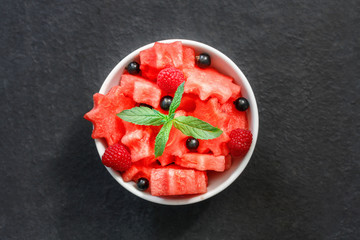 Salad of fresh juicy pieces of watermelon, raspberry and currant with green mint leaves