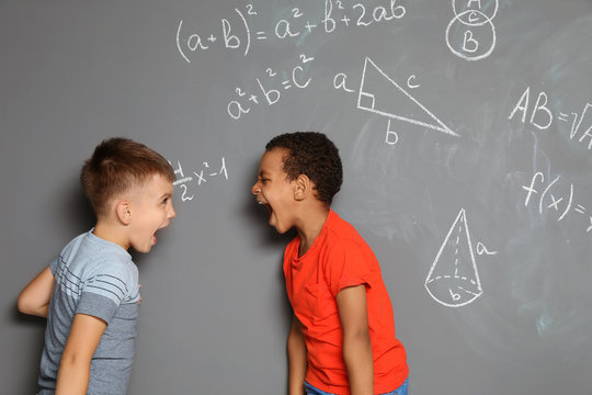 Little school children and mathematical formulas on grey background
