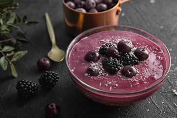 Bowl of tasty acai smoothie on dark table