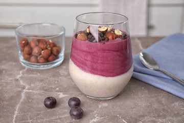 Glass with tasty acai smoothie on gray table