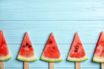 Flat lay composition with watermelon popsicles on wooden background