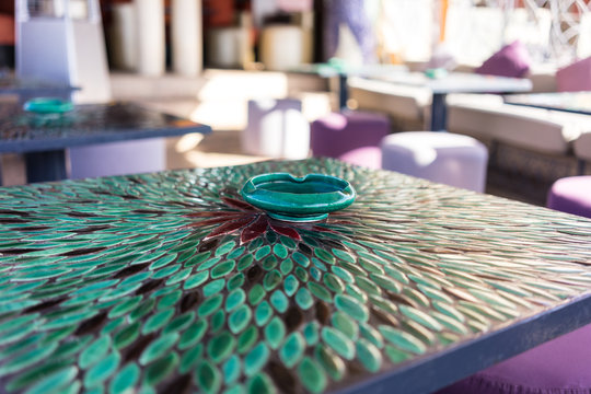 green mosaic table with flower pattern and ashtray