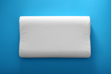 Soft bed pillow on color background, top view