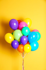 Bunch of bright balloons on color background. Festive decor