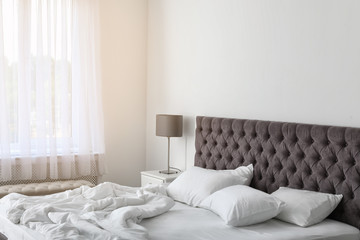Fototapeta na wymiar Soft white pillows on comfortable bed indoors