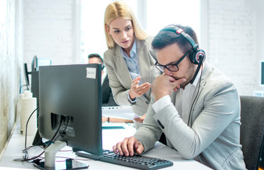 Female chief giving instruction to her worker. Problem in call center, male customer support worker...