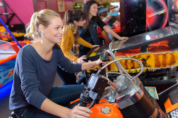 Woman on motorcycle arcade game - obrazy, fototapety, plakaty