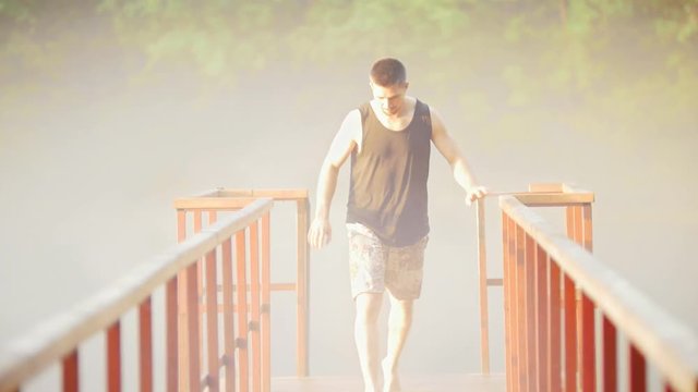 Young man doing backflip jumping on the bridge