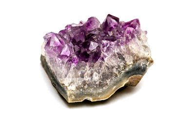 Crystals of amethyst on rock isolated on white background