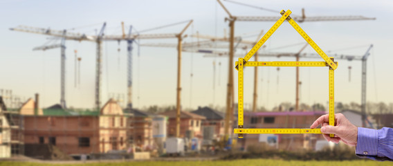 Neubaugebiet in Planung mit Meterstab als Modellhaus