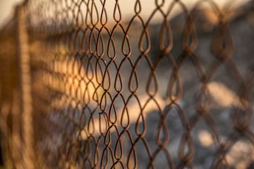 Reja difusa oxidada y abandonada en el campo limitando una parcela En un atardecer asombroso con una puesta de sol apoteosica