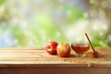 Honey and apples on wooden table