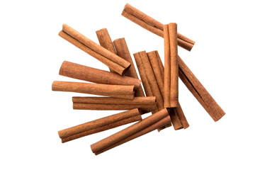 Heap of dry cinnamon sticks on white background