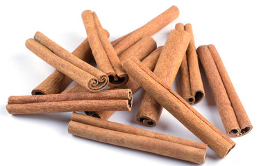 Heap of dry cinnamon sticks on white background
