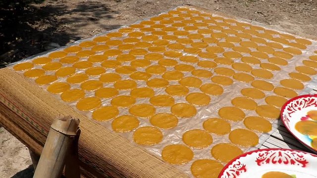 A slice of manga with bananas drying on the sun. A processing of manga at village farm, Thailand