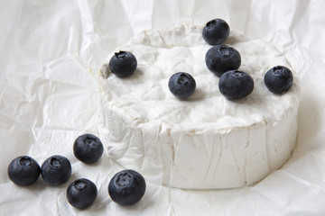 Camembert cheese in paper, closeup. Dairy product.