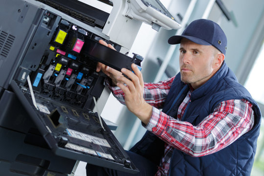 technician holding a screwdriver for fixing printer