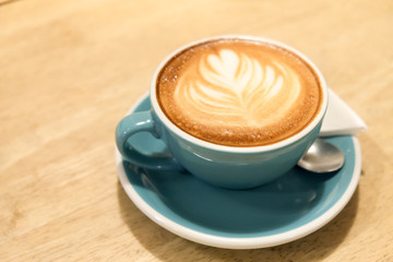 A cup of coffee Latte art green glass on wood table