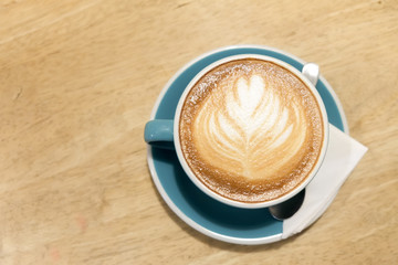 A cup of coffee Latte art green glass on wood table