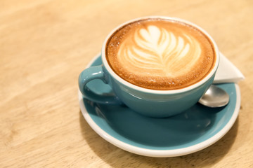 A cup of coffee Latte art green glass on wood table