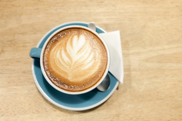 A cup of coffee Latte art green glass on wood table