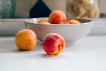 Fresh peaches on the white kitchen table. Local market products. Filtered image